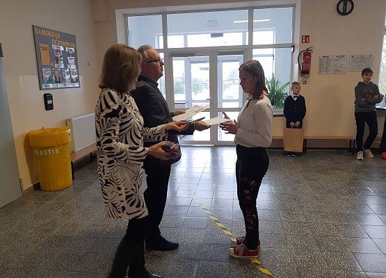 Pan Dyrektor i Pani Wicedyrektor wręczają uczennicy  nagrodę