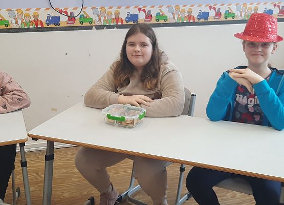 Uczennice siedzą w szkolnej ławce