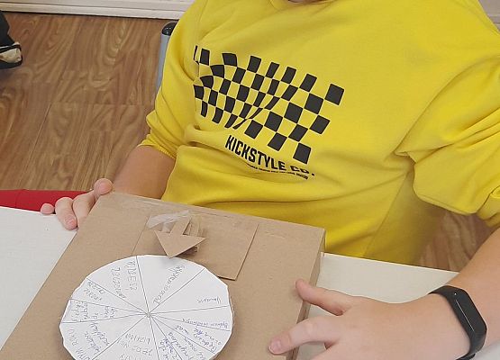 Uczeń siedzi a przed nim wróżba w kształcie koła