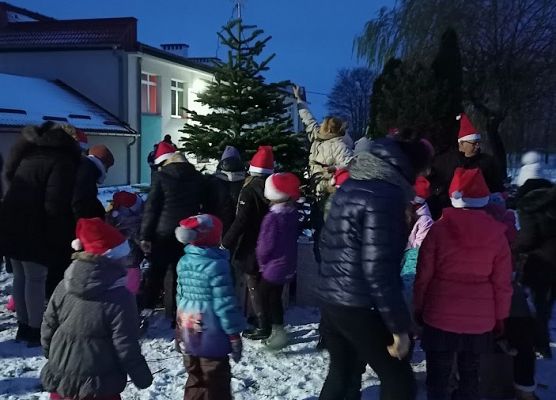 Dzieci chodzą po śniegu na placu przed szkołą