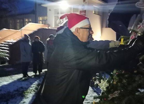 Dyrektor zawiesza ozdoby na choince