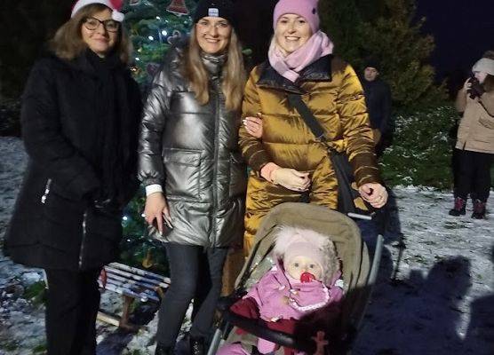 Trzy osoby na tle choinki