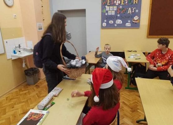 Uczennica rozdaje upominki wolontariuszom