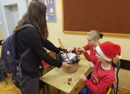 Uczennica rozdaje upominki wolontariuszom
