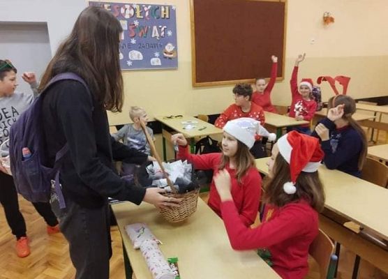 Uczennica rozdaje upominki wolontariuszom