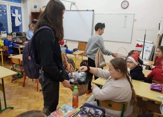 Uczennica rozdaje upominki wolontariuszom
