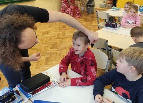 Pan pokazuje dzieciom grzyba, który ma kształt ucha