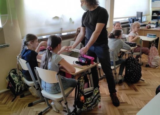 Pan pokazuje dzieciom trawę