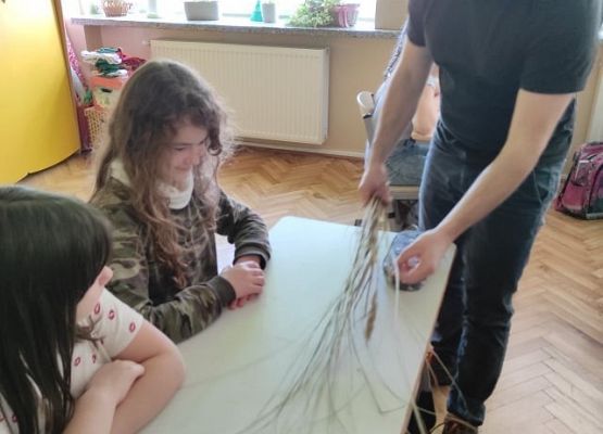 Pan pokazuje dzieciom trawę