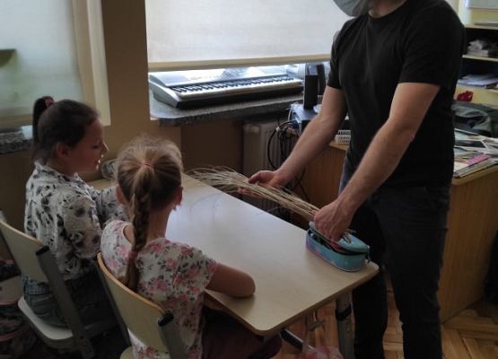 Pan pokazuje dzieciom trawę