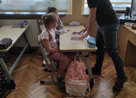 Pan pokazuje uczniom fotografię ryb