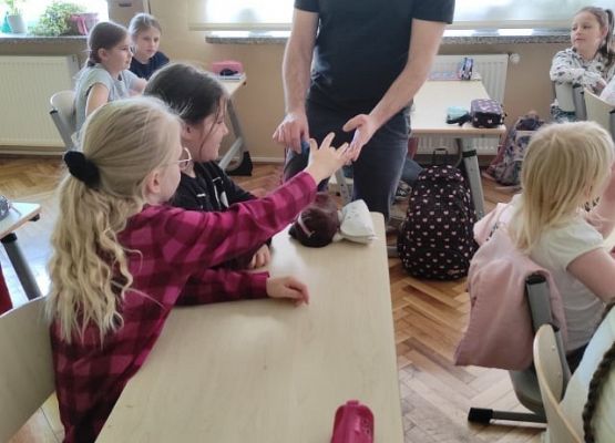 Uczniowie dotykają piasek