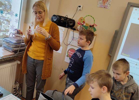 Nauczyciel pomaga uczniom w wykonaniu aniołka