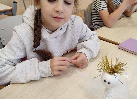 Uczennica ozdabia aniołka