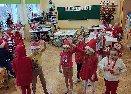Dzieci w mikołajkowych przebraniach stoją na podłodze