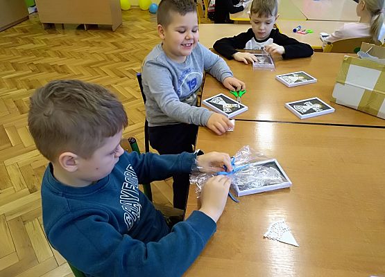 Dzieci wykonują aniołki z papieru