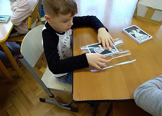 Chłopiec wkłada obrazek w ramkę