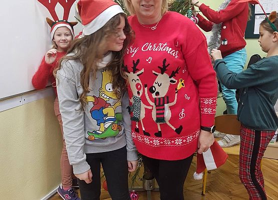 Nauczycielka z uczniami podczas ubierania choinki