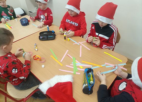 dzieci wykonują wykonany łańcuch na choinkę