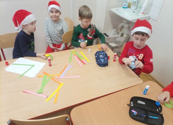 dzieci wykonują wykonany łańcuch na choinkę