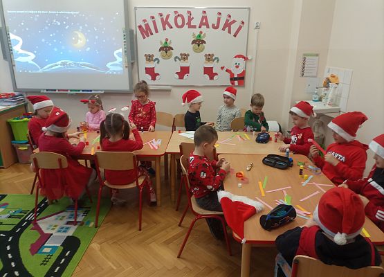 dzieci wykonują wykonany łańcuch na choinkę