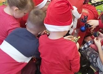 Grupa dzieci siedzi na dywanie