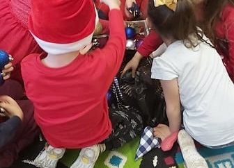 Grupa dzieci siedzi na dywanie