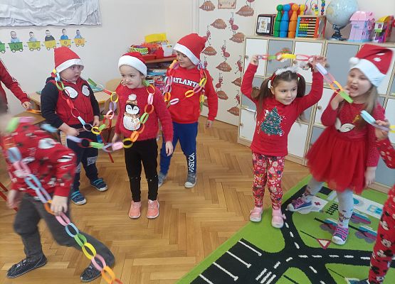 dzieci prezentują wykonany łańcuch na choinkę