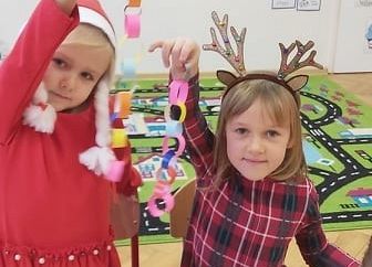 Dziewczynki robią z papieru łańcuch na choinkę