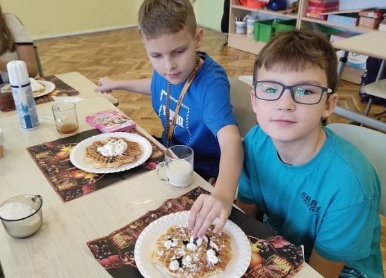 Dwaj uczniowie dekorują gofry