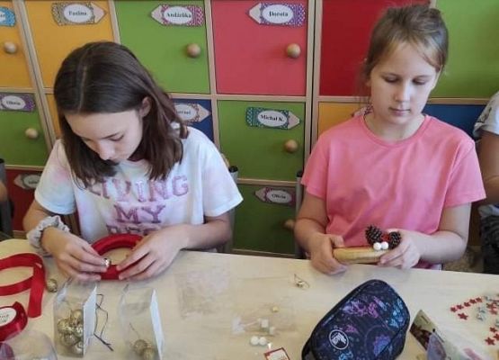 Uczennice przyklejają ozdoby do stroików