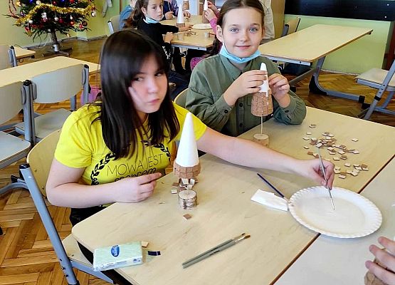 Uczniowie przyklejają elementy choinki