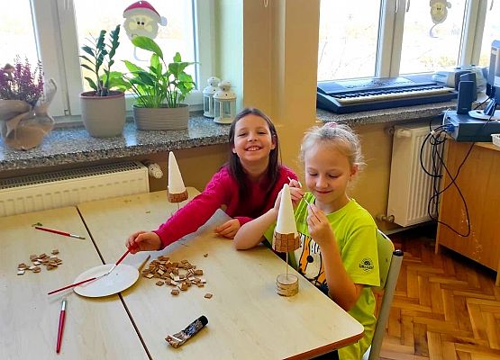 Uczniowie przyklejają elementy choinki
