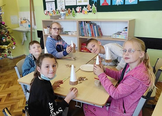 Uczniowie przyklejają elementy choinki