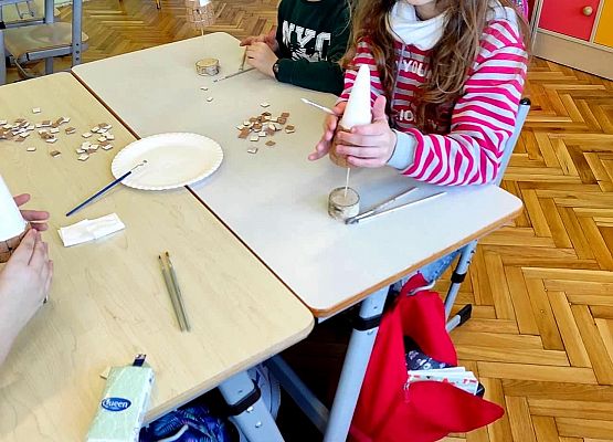 Uczniowie przyklejają elementy choinki