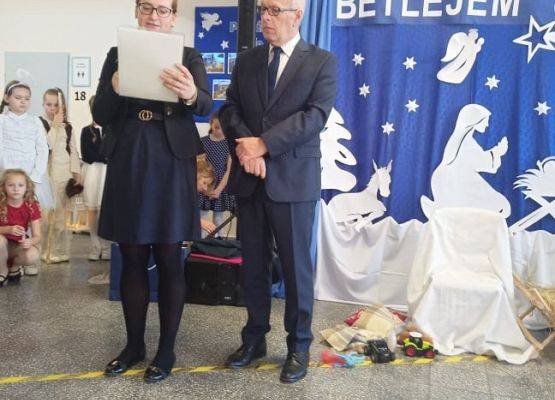 Dyrektor i pedagog odczytują dyplon