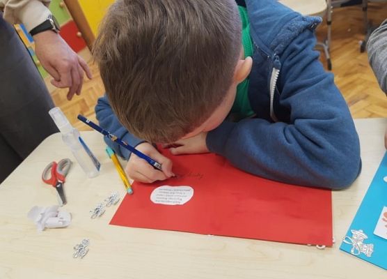 Uczeń pisze życzenia.