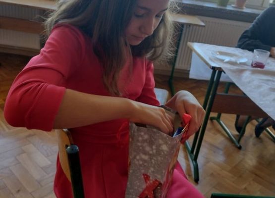 Uczennica rozpakowuje otrzymany prezent.