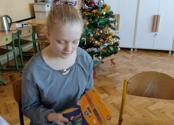 Uczennica rozpakowuje otrzymany prezent.