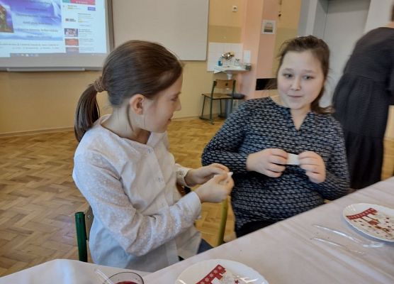 Uczennice dzielą się opłatkiem.