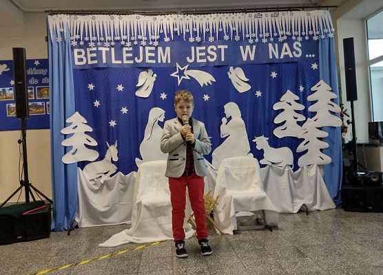 Uczeń stoi na scenie i śpiewa