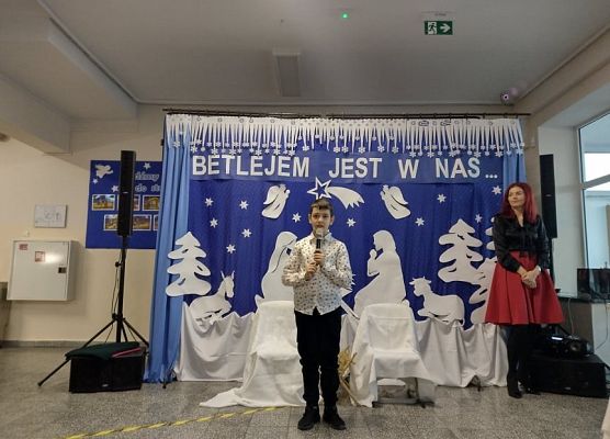 Uczeń stoi na scenie i śpiewa