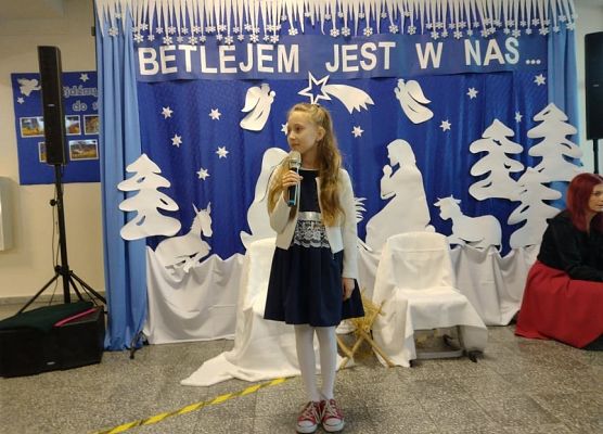 Uczennica stoi na scenie i śpiewa