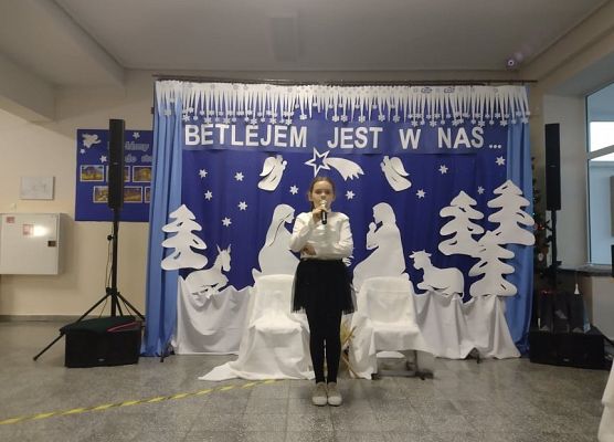 Uczennica stoi na scenie i śpiewa