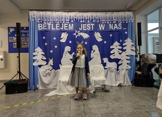 Uczennica stoi na scenie i śpiewa