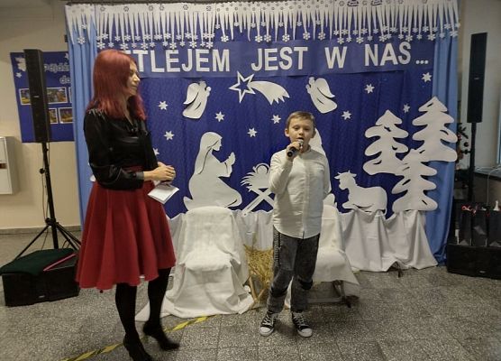 Uczeń stoi na scenie i śpiewa