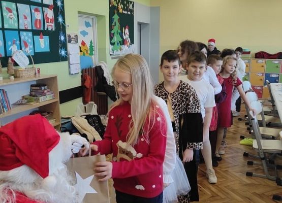 Uczennica odbiera prezent od Mikołaja