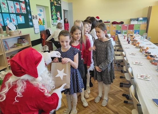 Uczennica odbiera prezent od Mikołaja