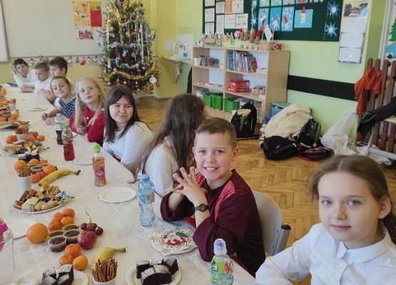 Uczniowie siedzą przy wigilijnym stole