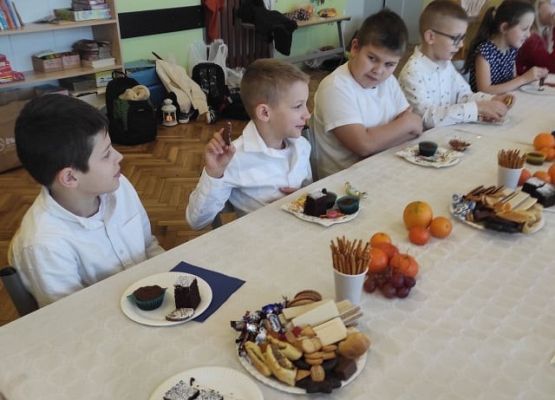 Uczniowie siedzą przy wigilijnym stole